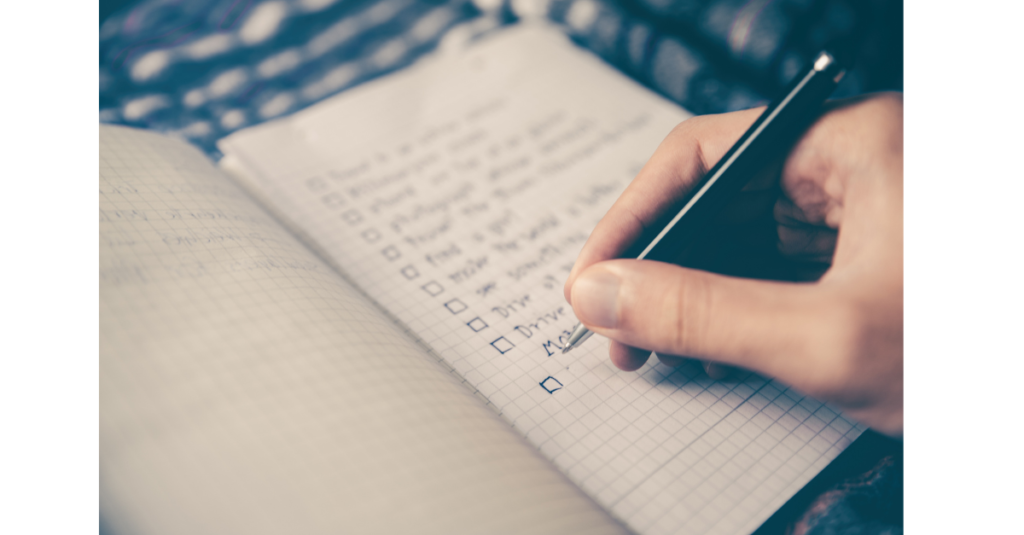 Man reviewing and writing on a checklist titled ‘Previous Year Goals,’ reflecting on accomplishments and planning for the year ahead, with a thoughtful and focused expression.